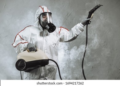 disinfector in a protective suit conducts disinfection in contaminated area. professional disinfection against COVID-19, coronavirus. in clothing protecting from chemical poisoning in the industry - Powered by Shutterstock