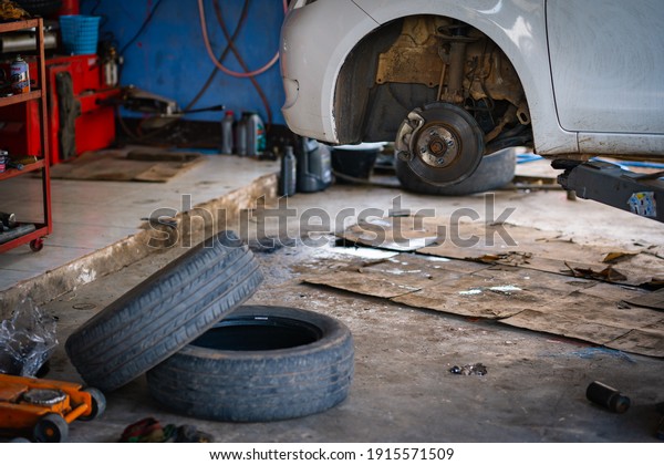 Disk wheel of car in\
automobile service, change tire repair of vehicle for safety of\
driver, disk brake pad of car on blurred background, checking\
system of machine