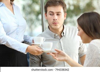 Disloyal Boyfriend Looking At Breast Of A Waiter In Front Of His Distracted Girlfriend