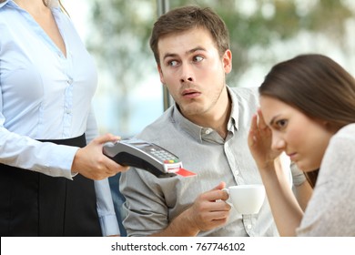 Disloyal boyfriend looking at waiter chest in front of his embarrassed girlfriend