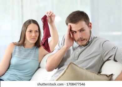 Disloyal Cheater Boyfriend Caught By Girlfriend Showing Underwear Of Another Girl On A Couch At Home