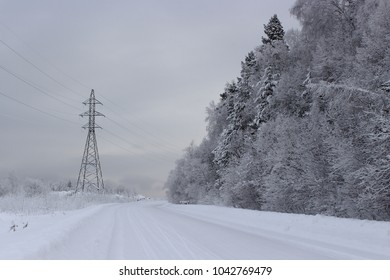 Dismal Winter Landscape Heavy Snowy And Frozen Power Lines, Mountain Road And Dark Forest . Fabulously Snowy Mountain Road In Siberia