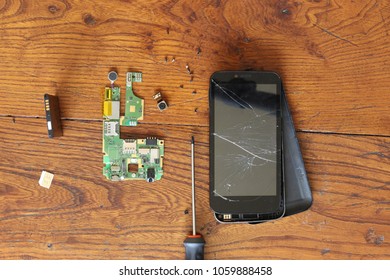 Dismantled Smartphone Put On A Wood Table.