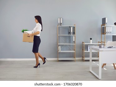 Dismissed Unemployed Woman Worker With A Cardboard Box In The Office Leaves In Search Of A New Job.