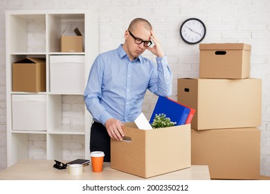 Dismission And Moving Day Concept - Sad Businessman Packing Things In Boxes For Moving