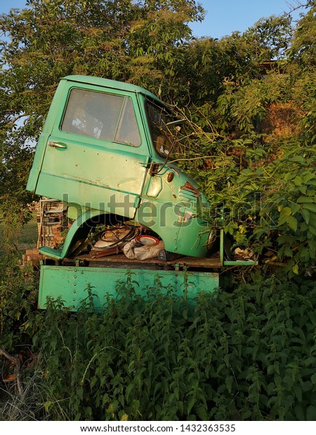 dismounted parts of\
a vintage truck on a\
meadow