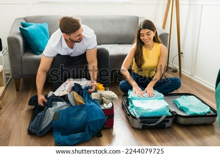 Disorganized man packing his suitcase with his girlfriend before going on a vacation trip