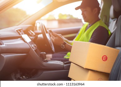 The Dispatcher Uses The Delivery Program Using A Mobile Phone. In The Van With Parcels On The Outside Of The Warehouse.