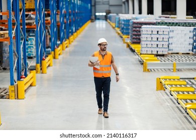 A Dispatcher Walking Trough The Warehouse With Order List In Hands.