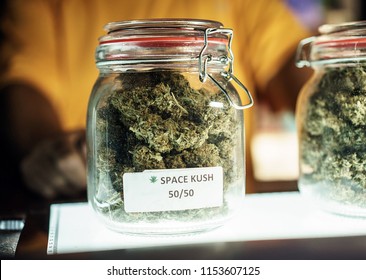 A dispensary worker vending a jar of cannabis. 