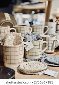 Display of assorted simplistic ceramic mugs on shelves