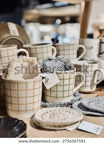 Display of assorted simplistic ceramic mugs on shelves