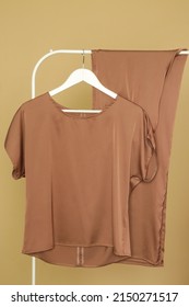 Display Of Brown Outfit On Clothing Rack In Fashion Studio.