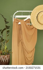 Display Of Brown Outfit On Clothing Rack In Fashion Studio.