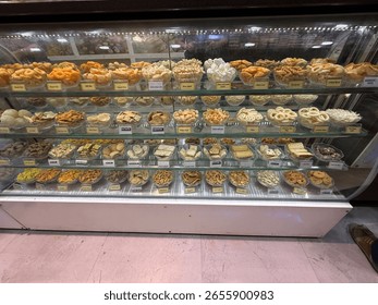 A display case of various snacks and sweets. The case is filled with many different types of food, including some that are shaped like animals. The case is open and the food is visible