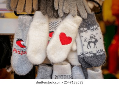 Display of colorful winter mittens featuring festive patterns and warm designs in a cozy market setting - Powered by Shutterstock