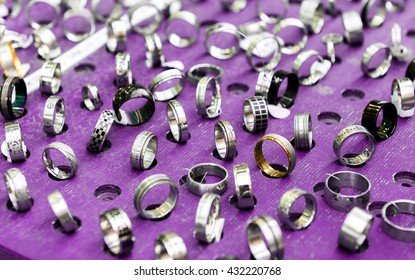 Display With Different Designs Of Handmade Silver Rings On Pink Stand. Close-up Of Handmade Jewelry Shop Window Display.