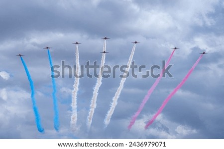 Display jet aircraft flying in formation with red white and blue smoke trails