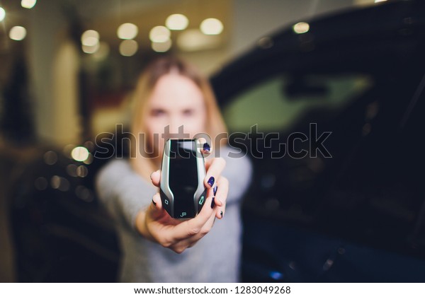 Display key Auto Rental Sale\
Dealer Agency. Automobile Buy concept. woman holds modern keys in\
hands