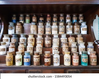 Display Of Traditional Chinese Medicine In Jars. Chinese Herb Store With Wooden Antique Cupboard For Dried Medical Drug Powder Storage. The Non-English Text In The Images Are 