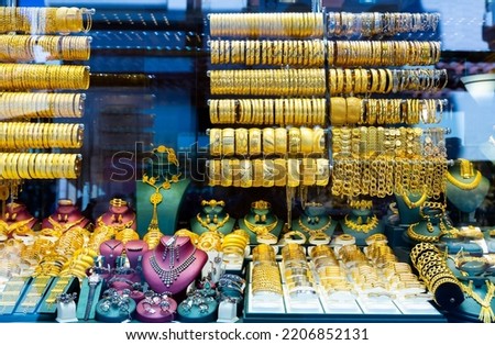 Display window with expencive gold jewelry. Bracelets, necklaces and chainlets for sale.
