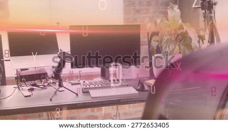 Displaying creator workstation featuring dual monitors, laptop on riser in home studio, with mic. Displays, computer, microphone, interface, mixer, keyboard, mouse