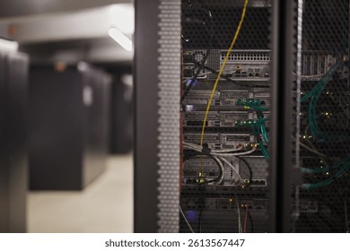 Displaying intricate wiring of server rack inside modern data center. Visible details include network cables and active hardware components in a controlled environment