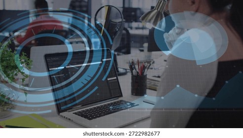Displaying laptop screen showing code in open-plan office, developer wearing dark sleeveless top. Computer, programming, coworking, visualization, monitors, focused, workspace