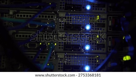 Displaying rack-mounted server blades inside server rack, showing teal Ethernet cables and LEDs. Cabinet, data, center, network, hardware, cabling, lights