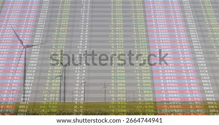 Displaying translucent financial table overlay covering grassy plain with wind farm, colored cells. Renewable, sustainability, technology, innovation, ecofriendly, analytics, aerial