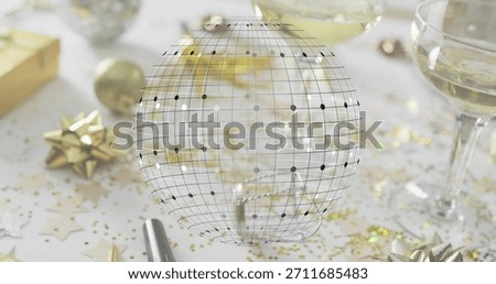 Displaying translucent wireframe globe hovering over party table, showing champagne glasses. Gold, confetti, festive, bokeh, sparkle, luxury, decor