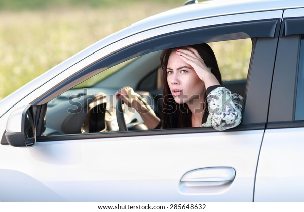 Displeased angry woman driving her\
car.Negative human\
expression.