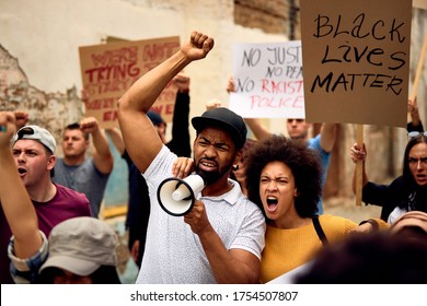 Displeased Black Couple Shouting While Marching With Group Of People On  Anti-racism Protest.