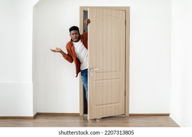 Displeased Black Guy Opening The Door Looking At Camera Expressing Discontent And Negative Emotions Standing At Home. Negative Real Estate News. Full Length