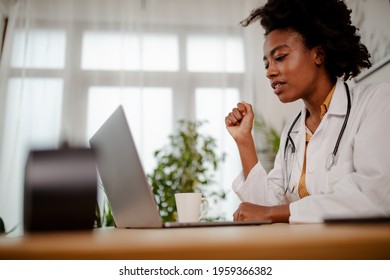 Displeased Black Healthcare Worker Using Computer And Reading An E-mail At Doctor's Office.