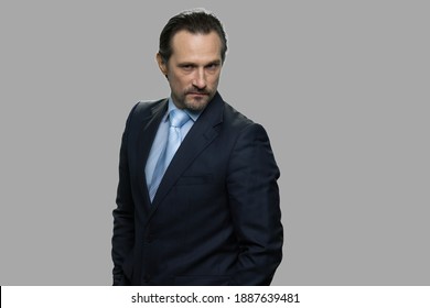 Displeased confident businessman on gray background. Portait of strict executive leader.