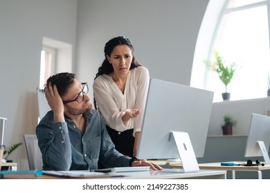 Displeased Female Boss Scolding Upset Subordinate, Pointing At Mistake In Business Project At Office. Male Worker Using Pc, Missing Deadline, Speaking To Unhappy Colleage, Feeling Stressed At Work