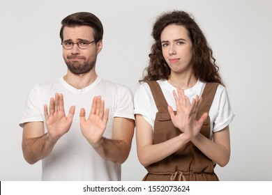 Displeased Millennial Couple Isolated On Grey Studio Background Look At Camera Denying Bad Sale Offer, Dissatisfied Unhappy Man And Woman Make Gesture Say No Reject Refuse Proposal Or Suggestion