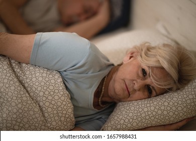 Displeased Senior Woman Thinking While Lying In Bed Awake Late At Night.