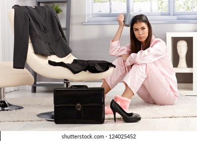 Displeased Tired Young Woman In Pyjama Getting Ready For Work, Sitting On Living Room Floor Surrounded With Business Clothes And Briefcase, Having Coffee.