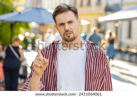 Displeased upset brunette bearded man reacting to unpleasant awful idea, dissatisfied with bad quality, wave hand, shake head No, dismiss idea, dont like proposal. Young adult guy on urban city street