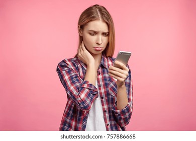 Displeased Upset Female Curves Lip, Being Unhappy To Recieve Bill From Banking Service On Mobile Phone, Has No Money To Pay, Feels Frustrated And Disappointed, Isolated Over Pink Background.