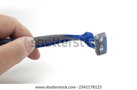 Disposable blue razor in men hand isolated on white background. Сlose-up