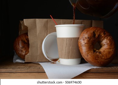 A disposable cup of coffee and bag of bagels. A to-go breakfast meal  - Powered by Shutterstock