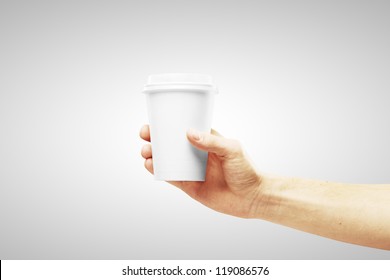 disposable cup of coffee in hand