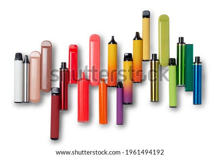 Disposable e-cigarettes on white isolated background laid out in the colors of the rainbow. The concept of modern smoking, vaping and nicotine. Top view