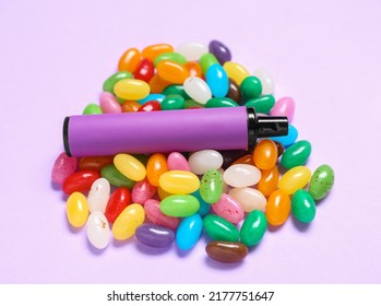 Disposable electronic cigarette and candies on purple background