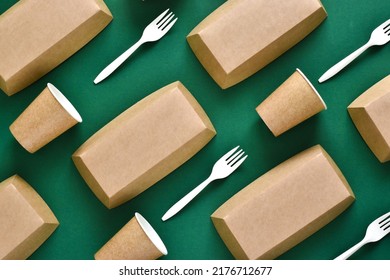 Disposable Environmentally Eco-friendly Food Packaging. Brown Craft Paper Containers, Drink Glasses And Forks On A Green Background. Top View, Flat Lay Composition. Mockup, Template 