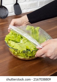 Disposable Food Storage Lids. Cellophane Bag From Drying Food. Kitchen Utensil Concept. Woman Closes The Lettuce Leaves