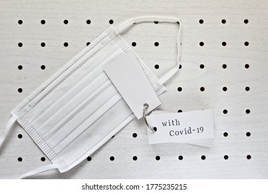 A Disposable Mask And A Vocabulary Book On The Punching Board. The Words 